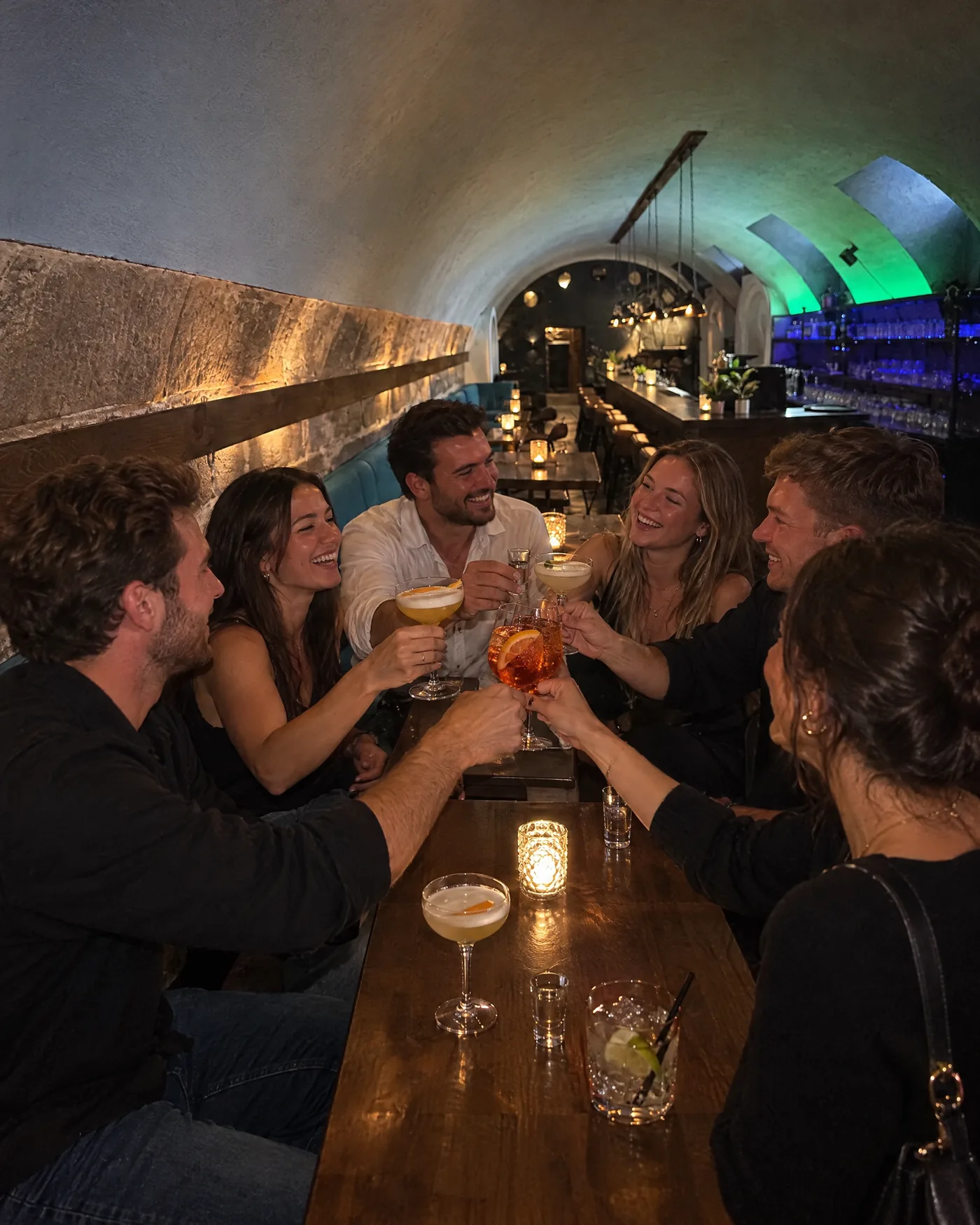 Gruppe stößt am langen Tisch im Gewölbe des Pub&Go Fürth an
