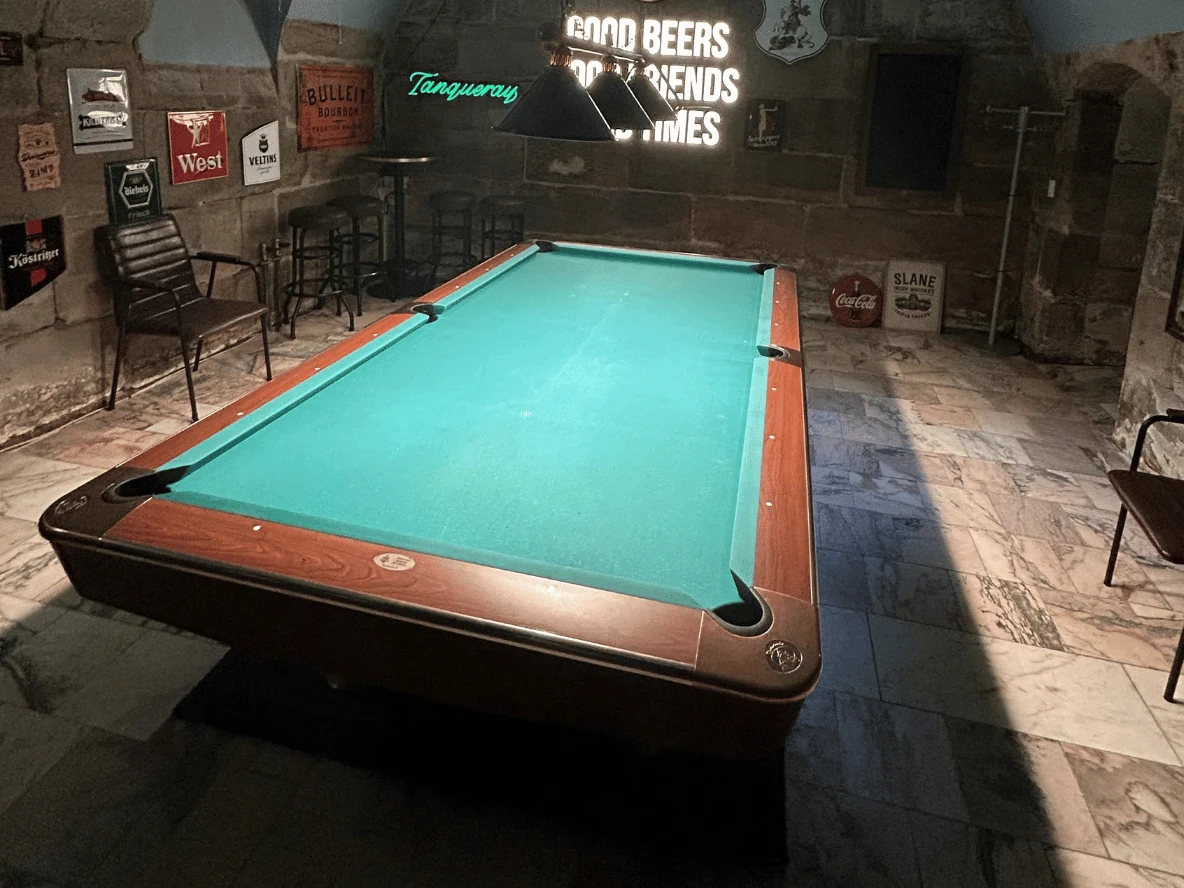 Pooltisch im Gewölbe von Pub&Go Fürth mit Barhockern und Wandschildern